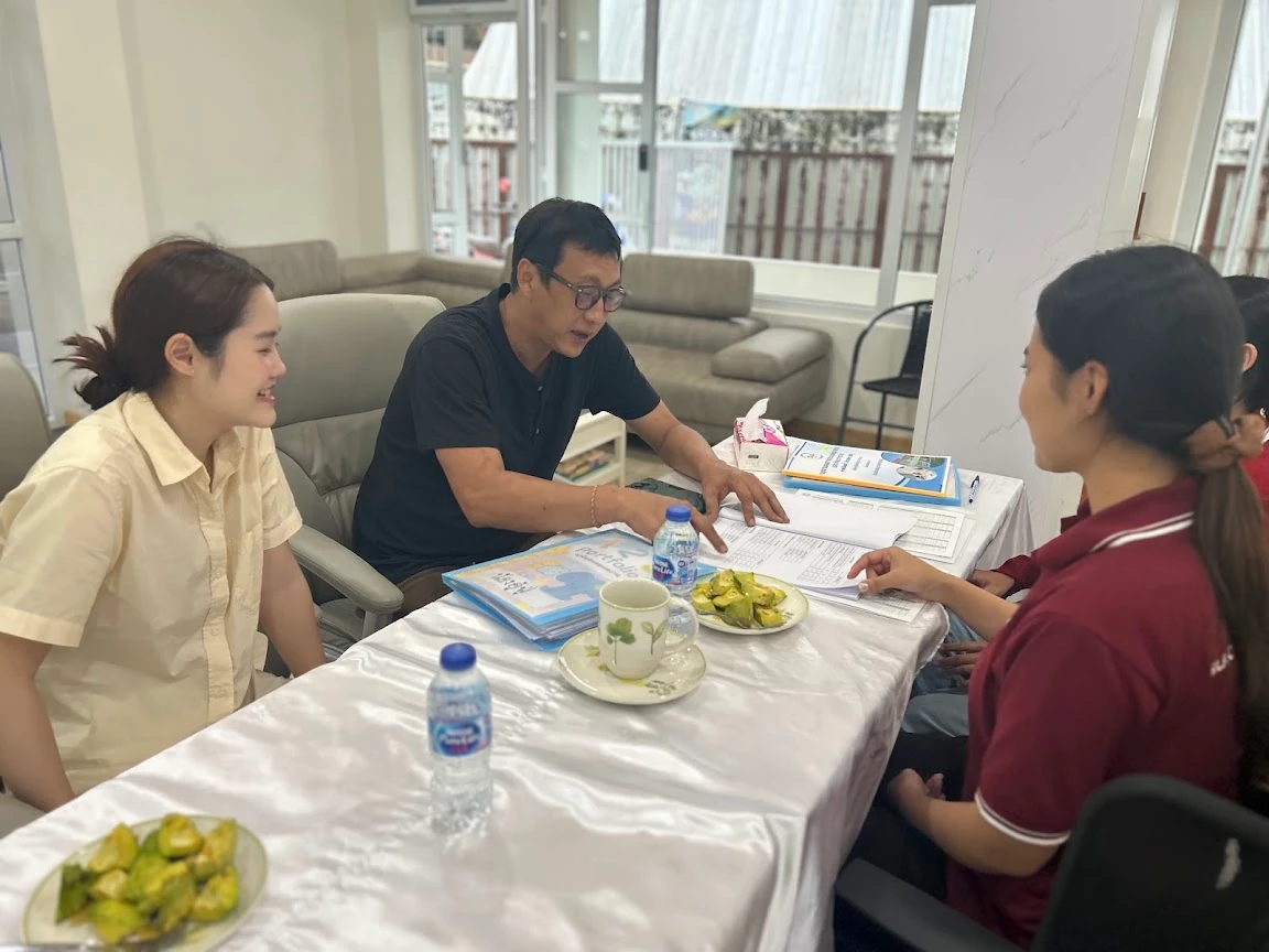 Parents talking with a SiLA teacher across a table during a school visit
